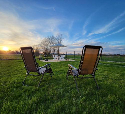 two chairs sitting in the grass in a field at Chochołowska Przystań in Chochołów