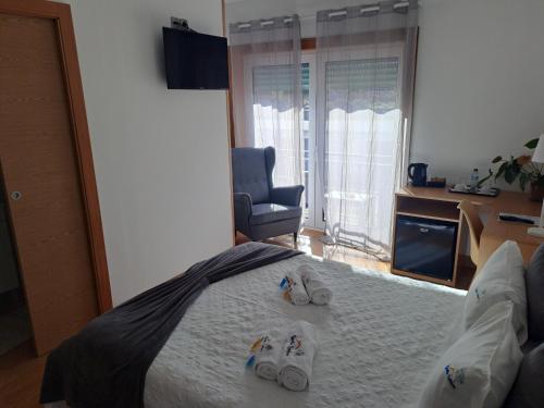 a bedroom with a bed with a pair of shoes on it at Quinta Salinas - Puro Prazer in Aveiro