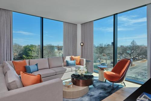 a living room with a couch and chairs and large windows at The Crescent Hotel, Fort Worth in Fort Worth