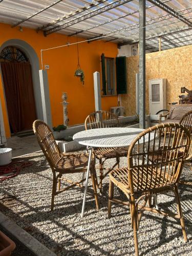 a patio with a table and chairs on a patio at Carlitos MAISON in Pisa