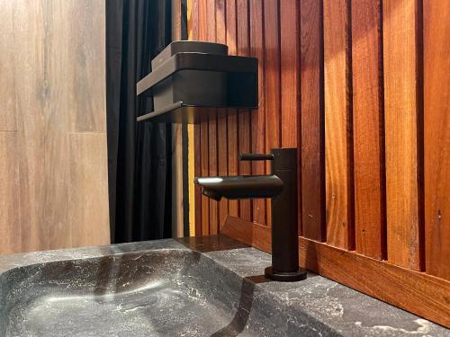 a bathroom sink with a faucet in a wooden wall at Jan Kok Lodges in Willibrordus