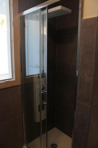 y baño con ducha y puerta de cristal. en LA CASETTA 3.0, en Calimera