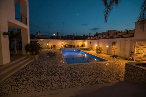 a swimming pool in the courtyard of a house at night at LA CASETTA 3.0 in Calimera