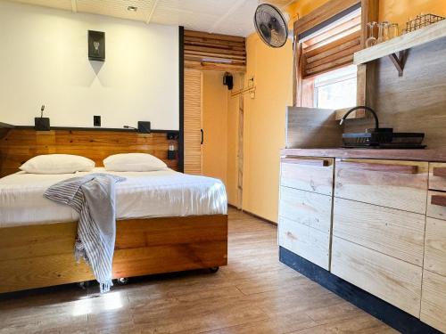 a bedroom with a large bed and a wooden dresser at Jan Kok Lodges in Willibrordus