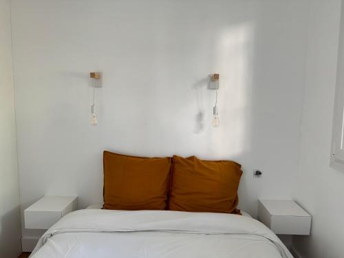 1 dormitorio con 1 cama con 2 mesitas de noche blancas en Le balcon de la Rade, en Cassis