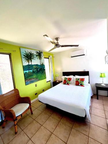 a bedroom with a white bed and a chair at LoneStar Tico in Sardinal