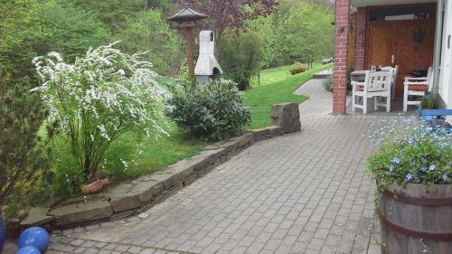 a garden with a brick walkway next to a house at Ferienwohnung Blum in Antweiler