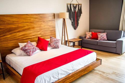 a bedroom with a large bed and a couch at Studio 2 blks 5th beach shops ac in Playa del Carmen