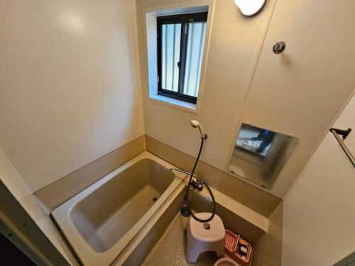 een kleine badkamer met een bad en een wastafel bij Toso Youth Travel Village - Vacation STAY 30455v 