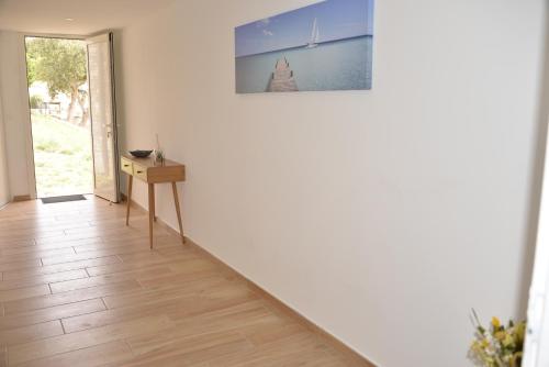 a hallway with a table and a picture on the wall at Gite Le soleillou in Reynès