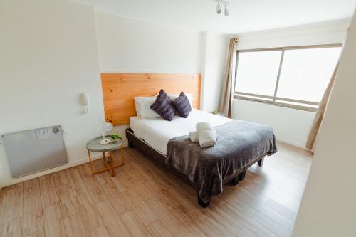 a bedroom with a large bed and a window at Agua Marina - La Serena in La Serena