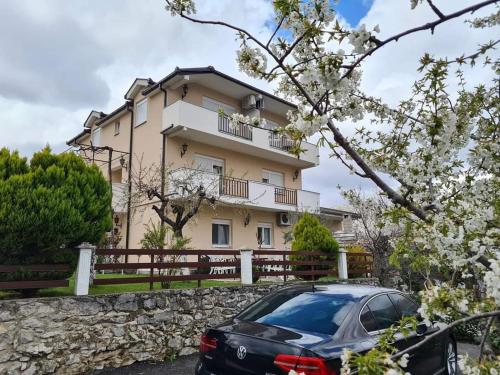 a house with a car parked in front of it at Studio apartmani Milović in Trebinje