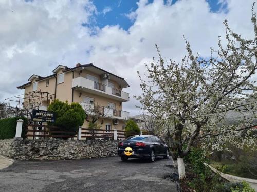 a black car parked in front of a house at Studio apartmani Milović in Trebinje