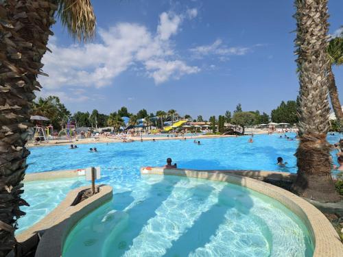 une grande piscine avec des gens dans un complexe hôtelier dans l'établissement La Carabasse Les Mazets 101, à Vias