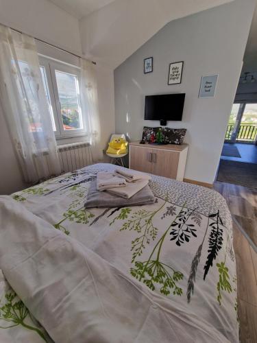 a bedroom with a bed with a blanket on it at Studio apartmani Milović in Trebinje