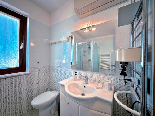 uma casa de banho branca com um lavatório e um WC em THE TERRACE em Alba Adriatica