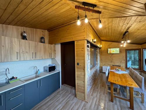 una cucina con soffitto in legno e tavolo in legno di Villa Raiski kyt a Dospat