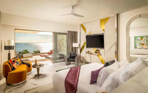 a bedroom with a bed and a view of the ocean at Hotel Mousai Cancun Adults Only - All Inclusive in Cancún