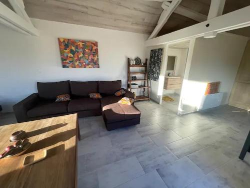 un salon avec un canapé et une table dans l'établissement Maison chaleureuse de campagne, à Venizy