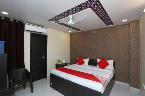 a bedroom with a large bed with red pillows at Flagship Richa Grand Inn Near Sahara Ganj Mall in Lucknow