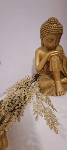 a gold statue of a buddha sitting on a table at The Palm Villa in St Paul's Bay
