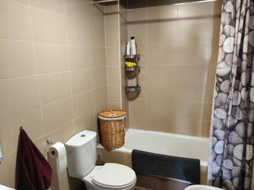 ein Badezimmer mit einem WC und einer Badewanne in der Unterkunft apartamento familiar con piscina in Camarma de Esteruelas