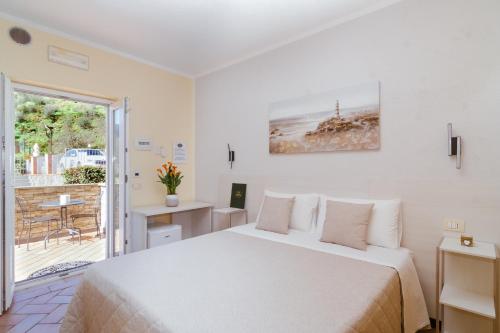 a white bedroom with a bed and a balcony at B&B Vignola in Levanto