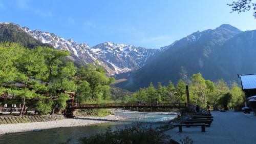 a bridge over a river with mountains in the background at Nakanoyu Onsen Ryokan - Vacation STAY 18794v in Matsumoto