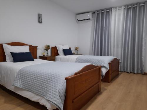 a bedroom with two beds and a window at CASA do AÇÔR in Aldeia das Dez