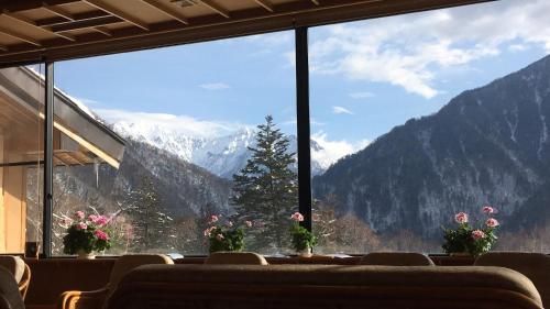 a room with a large window with a view of mountains at Nakanoyu Onsen Ryokan - Vacation STAY 18789v in Matsumoto
