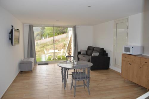 a living room with a table and a couch at Gite Le soleillou in Reynès