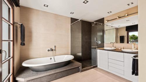 een badkamer met een bad, 2 wastafels en een douche bij Luxury 3 bed Villa in top location - Heating Pool in Marbella