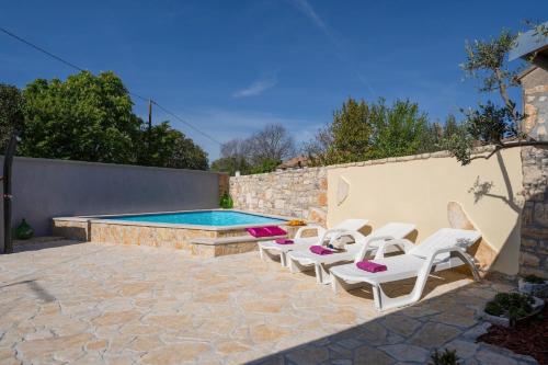 un patio con sedie e una piscina di Ferienhaus mit Privatpool für 5 Personen ca 100 qm in Butkovici, Istrien Binnenland von Istrien a Butkovići