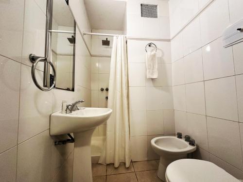 a white bathroom with a sink and a toilet at Castelar Hotel Santa Fe in Santa Fe