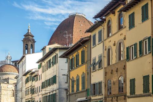 a group of buildings with a clock tower in the background at Casa San Lorenzo - Mercato Centrale in Florence
