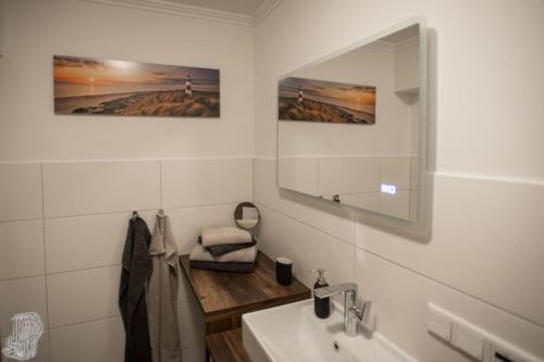a bathroom with a sink and a mirror at Ferienwohnung Ruheinsel in Büsumer Deichhausen