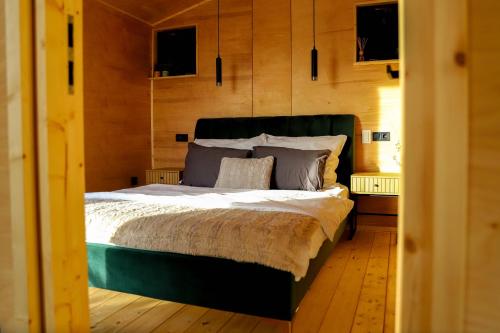 um quarto com uma cama grande e paredes de madeira em ChillHouse by Kis Veréb em Békésszentandrás