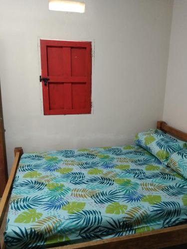 1 dormitorio con 1 cama con puerta roja en Finca hostal La Alicia 1950, en Santa Marta