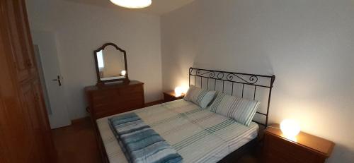 a bedroom with a bed with a mirror and two lamps at Duino Holiday in Duino