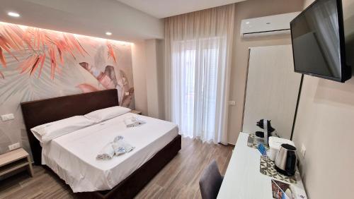Habitación de hotel con cama y TV de pantalla plana. en ARIA DI MARE LUXURY B&B, en Marina di Schiavonea