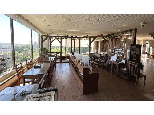 um restaurante com mesas e cadeiras e janelas grandes em Hotel Hounomai Otofuke - Vacation STAY 29513v em Otofuke