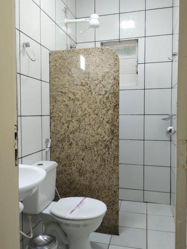 a bathroom with a toilet and a sink at Hotel American in Ariquemes