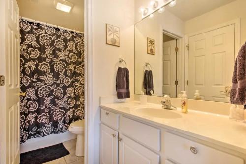 a bathroom with a sink and a toilet and a mirror at Waterfront Condo with Boat Slip! in Lake Ozark