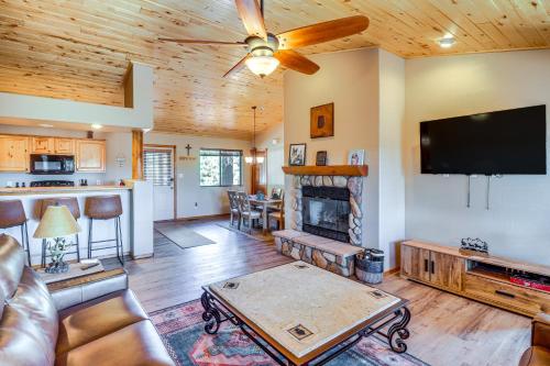 a living room with a fireplace and a flat screen tv at Near Lakes and Trails Pet-Friendly Cabin in Arizona in Overgaard