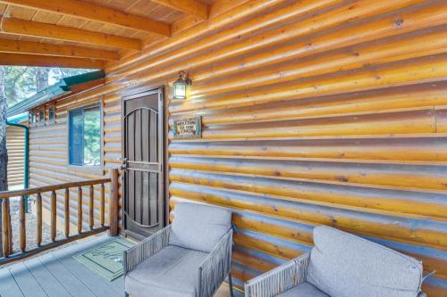 a cabin with two chairs on a porch at Near Lakes and Trails Pet-Friendly Cabin in Arizona in Overgaard