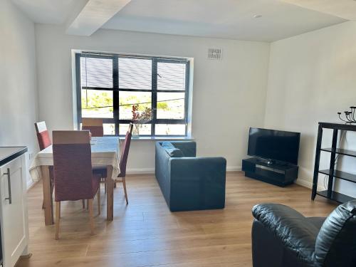 ein Wohnzimmer mit einem Esstisch und einem TV in der Unterkunft Wellington Central Apartment in Waterford