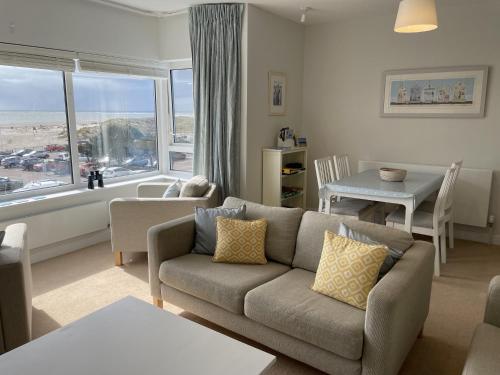 - un salon avec un canapé et une table dans l'établissement Lovely seafront 2 bedroom Apartment 4, à Aberdyfi
