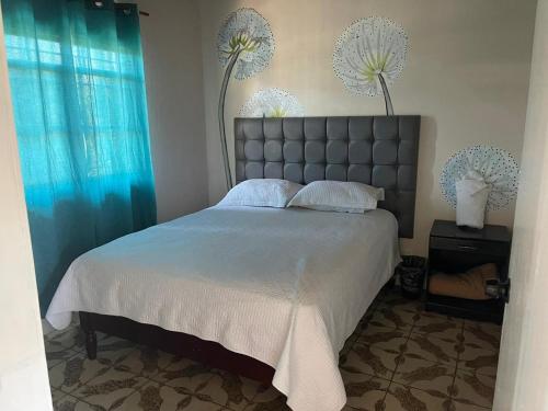 - une chambre avec un grand lit et des rideaux bleus dans l'établissement Departamento Hotel Cuatros Caminos, à Etzatlán