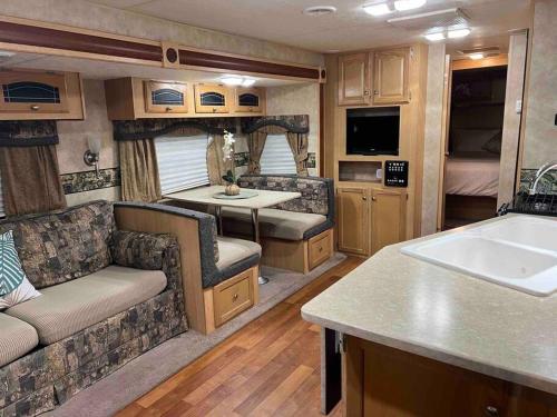 an rv living room with a couch and a sink at WARM AND COZY RV 3 in Miami