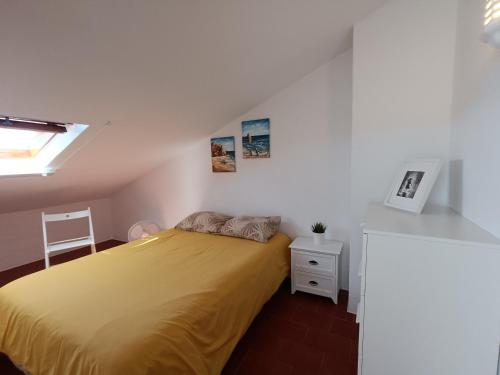 1 dormitorio con 1 cama con colcha amarilla en Apartamento Praia da Gale en Albufeira